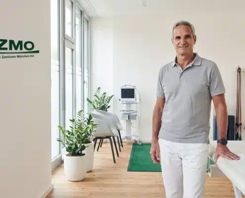 Orthopäde im hellen Therapieraum des Orthopädie Zentrums München Ost, wo Schulterschmerzen behandelt werden